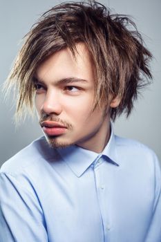 Portrait of young man with fringe messy hairstyle. studio shot.