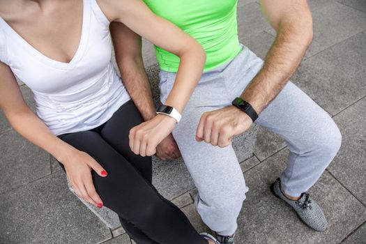 Two people using smart sport watch at workout.