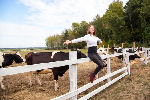 Freedom girl. Sitting on fence. Pause after work in milk farm. Outdoor
