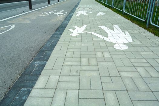 Cycle path next to footpath and white horizontal warning signs