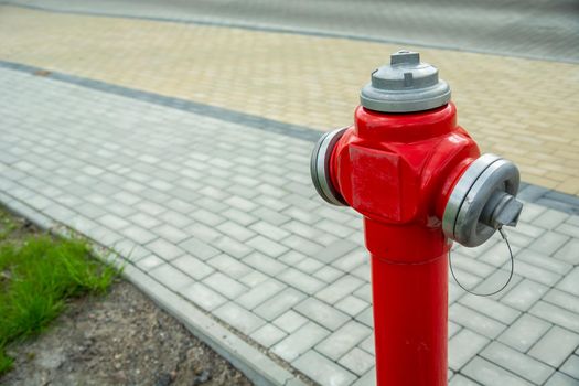 New red fire hydrant standing by the town footpath