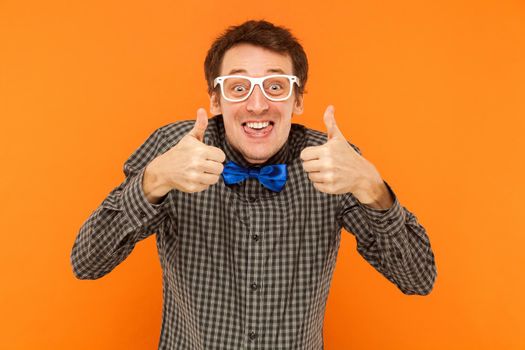 Crazy scentist tongue out and thumbs up. Studio shot. Isolated on orange background