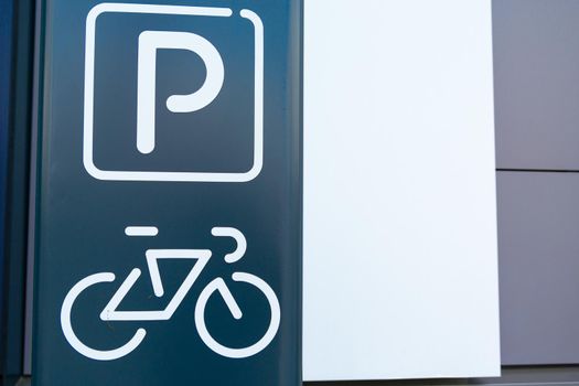 Symbol of a bicycle parking facility painted on the facade of a modern building, close up