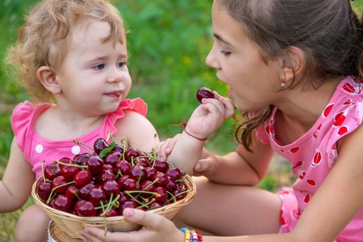 The child eats cherries in the garden. Selective focus. Food.