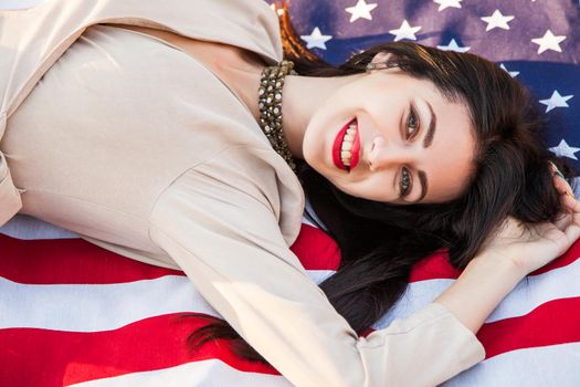 Beautiful happy woman with American flag celebrating independence day.