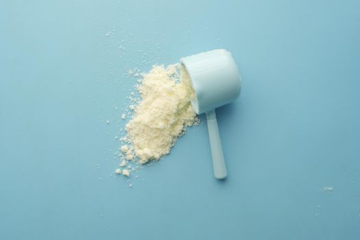 Close up of baby milk powder and spoon on tile background