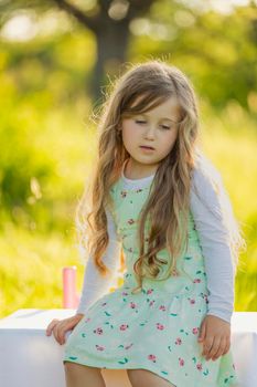 little girl in nature with a glass of orange juice