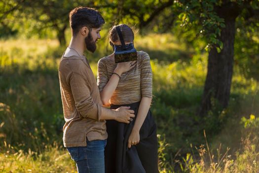 couple in nature, girl in virtual reality glasses close-up