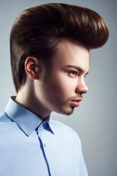 Side view of young man with retro classic pompadour hairstyle. studio shot.