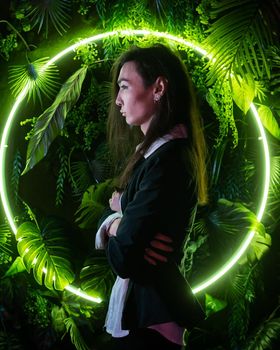 Portrait of an Asian man against the background of a circular lamp in the studio with neon light