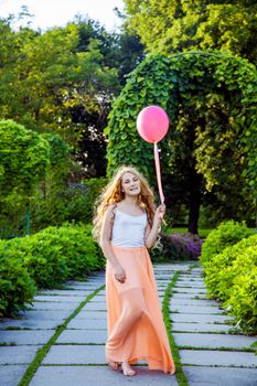 Portrait of happy girl with air balloon enjoying in the park on summertime.