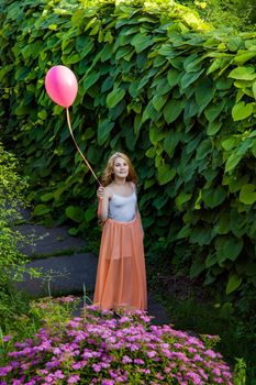 Portrait of happy girl with air balloon enjoying in the park on summertime.