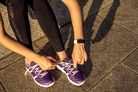 Running shoes. Barefoot running shoes closeup. Female athlete tying laces for jogging on road in minimalistic barefoot running shoes. Runner getting ready for training. Sport lifestyle.