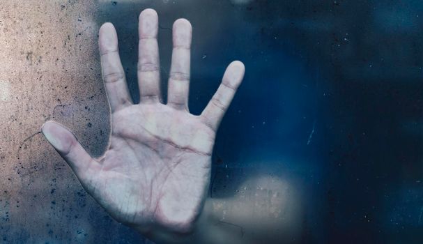 angerous man hand behind the frosted glass.Mystery man. abstract Halloween background