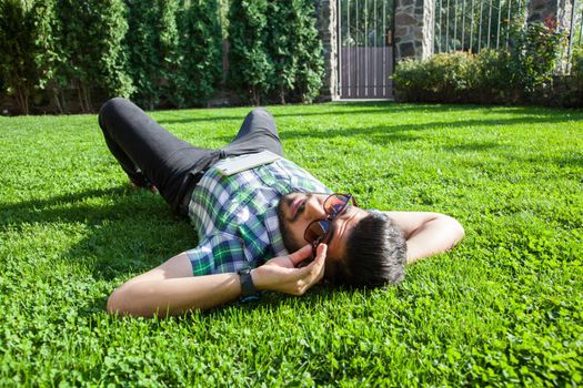 young man lie down on lawn and enjoying summertime.