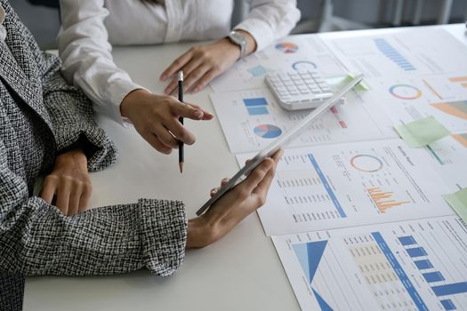 Business people explain working plans using graphs and tablet in the office. Meeting to analyse and discuss and brainstorming the financial report chart data in office