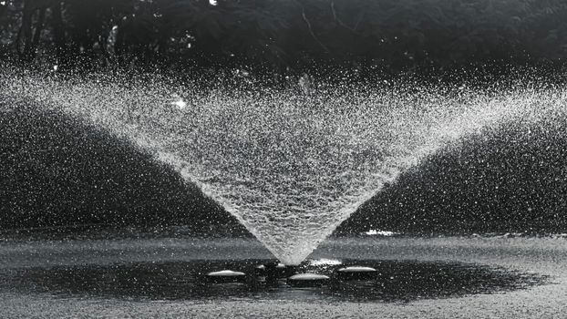 Realistic water fountain. fountains with water jets over pond in public park.