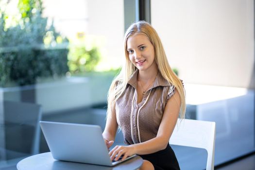 Beautiful young woman working using computer laptop concentrated and smiling