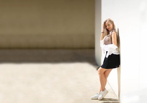 Portrait of young beautiful woman blonde hair standing against wall with copy space