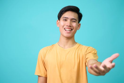 Happy and friendly man give warm welcome hug to dear guest, spread hands in cuddle or embraces, smiling greeting person with love, standing blue background.