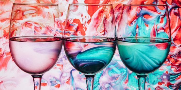 Three wine glasses in a row with colorful light painting behind, Set of three wine glasses with red, white and rose wine, banner, alcohol drinks