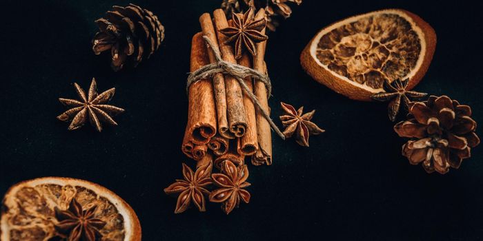 Background of dry slices of orange, cinnamon and star anise, ingredients for preparation mulled wine on black background, Christmas spices