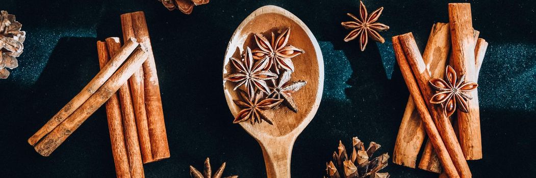 wooden spoon with star anise, cinnamon sticks, cones, christmas spices background, ingredients for wine