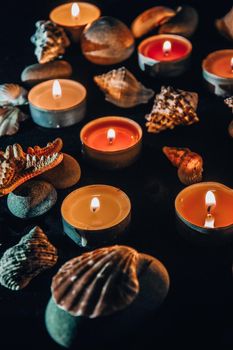 Candles, stones and shell in spa, light at night, sea spa concept, composition of spa treatment, selective focus