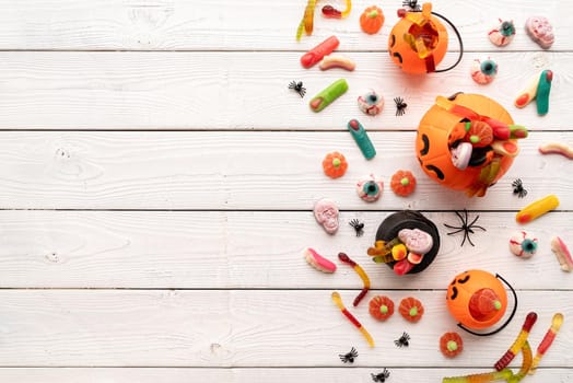 Halloween concept. Colorful sweets for Halloween party on white wooden background, top view flat lay