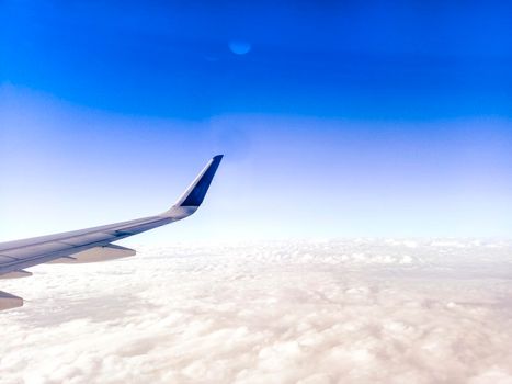 Wing of the plane on blue sky background .  Airplane Wing in Flight from window, blue sky . travel concept idea .
