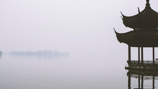 ancient pavilion on the west lake with sunset in hangzhou,China