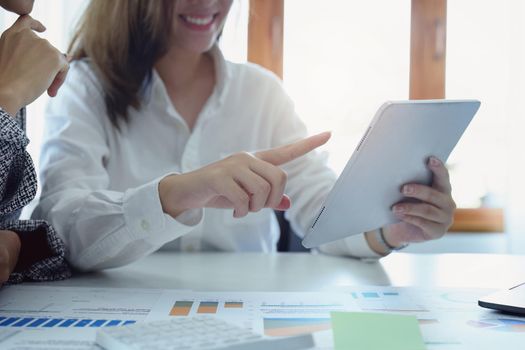 young Asian businesswoman using tablet computers to plan marketing strategies and invest to profit from customers.