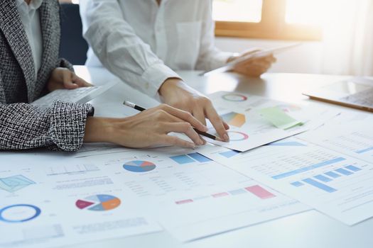 two young Asian businesswoman using their documents to plan marketing strategies and investments to profit from their clients.