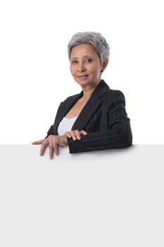 Mature business woman showing blank sign board. Asian busineeswoman in suit presenting billboard isolated on white background