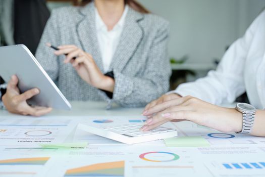 young Asian businesswoman using tablet computers to plan marketing strategies and invest to profit from customers.