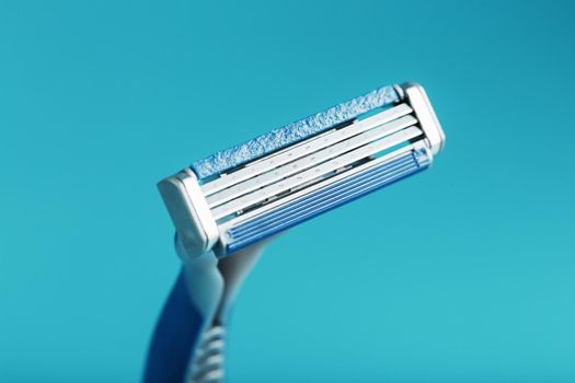 Three shaving machines on a blue background with free space, top view