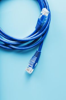 A coil of RJ45 Cat.6 Ethernet Network Internet Cable isolated on a blue background with free space