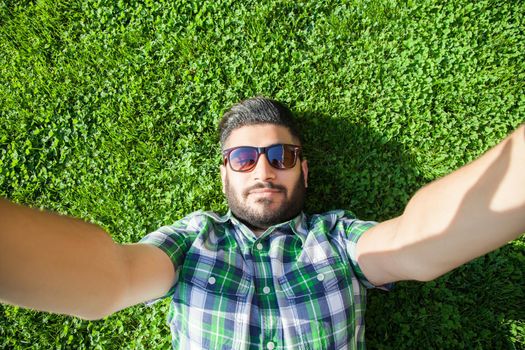 young man lie down on lawn and enjoying summertime.