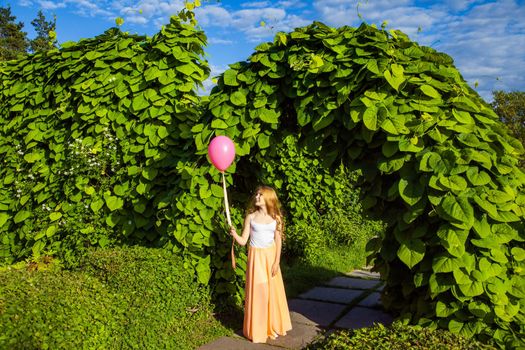 Portrait of happy girl with air balloon enjoying in the park on summertime.