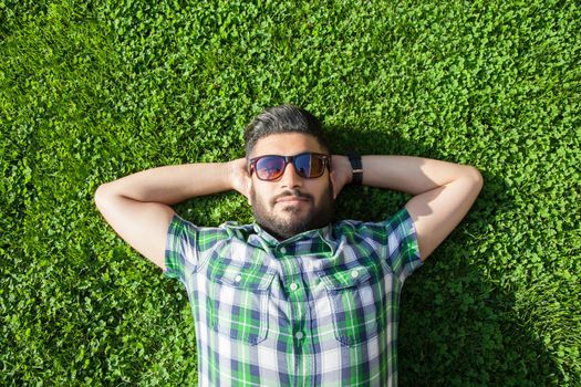 young man lie down on lawn and enjoying summertime.