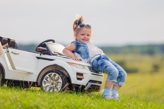 little girl standing near her baby car