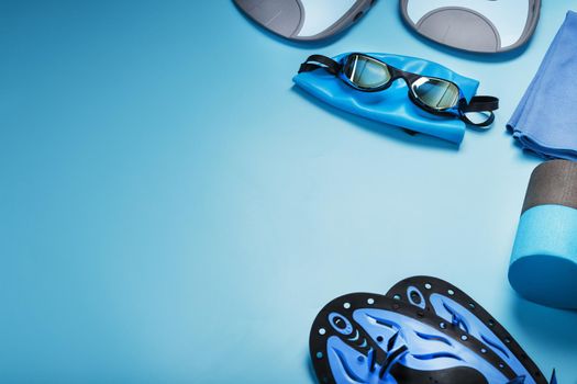 Sports equipment for swimming in the pool and open water on a blue background, close-up