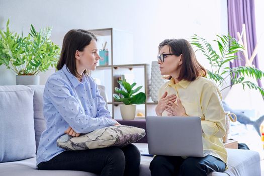 Young woman patient on individual therapy in psychologists office. Mature female concellor listening taking notes talking. Psychology, psychiatry, treatment, mental health concept