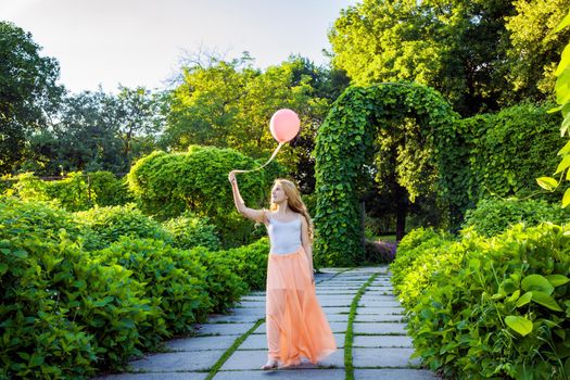 Portrait of happy girl with air balloon enjoying in the park on summertime.