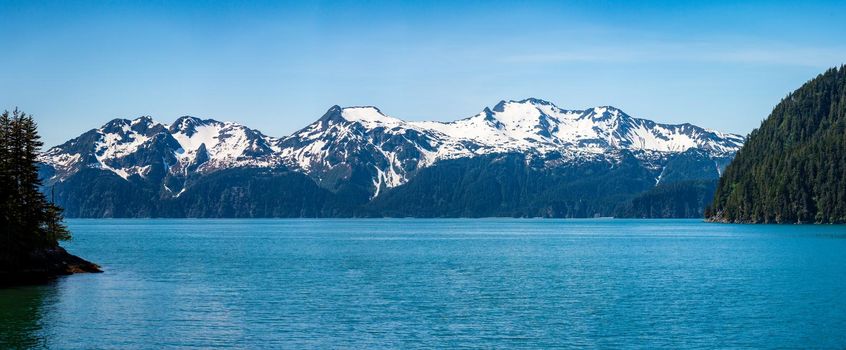 Wide panorama of snow covered peaks of the mountains overlooking Resurrection Bay near Seward in Alaska