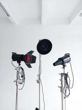 Professional lighting equipment, flashes, c-stands on a cyclorama in modern photo studio. Octabox, stripbox, softbox, buety plate and other stuff for photography