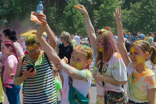 Novokuznetsk, Kemerovo region, Russia - June 12, 2022 :: Children with colorful faces painted with holi powder having fun outdoors.