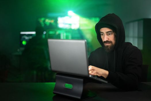 Male hacker using laptop typing bad data into computer online system. Copy space. Hacking and malware concept.