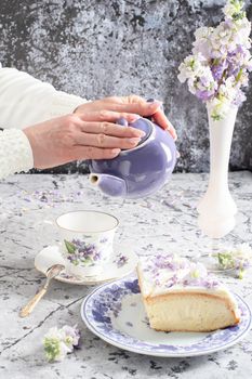 still life with black tea and cheese cake, spring bouquet of delicate lilac flowers. High quality photo