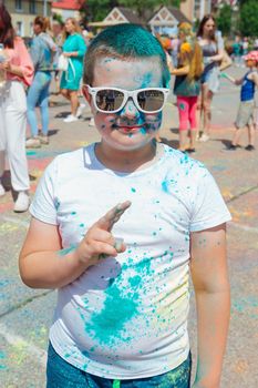 Novokuznetsk, Kemerovo region, Russia - June 12, 2022 :: Boy with colorful face painted with holi powder having fun outdoors.